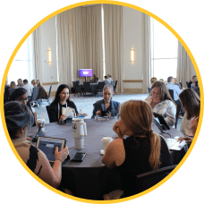 MOMENTUM attendees seated at a table interact during a Customer Success Roundtable